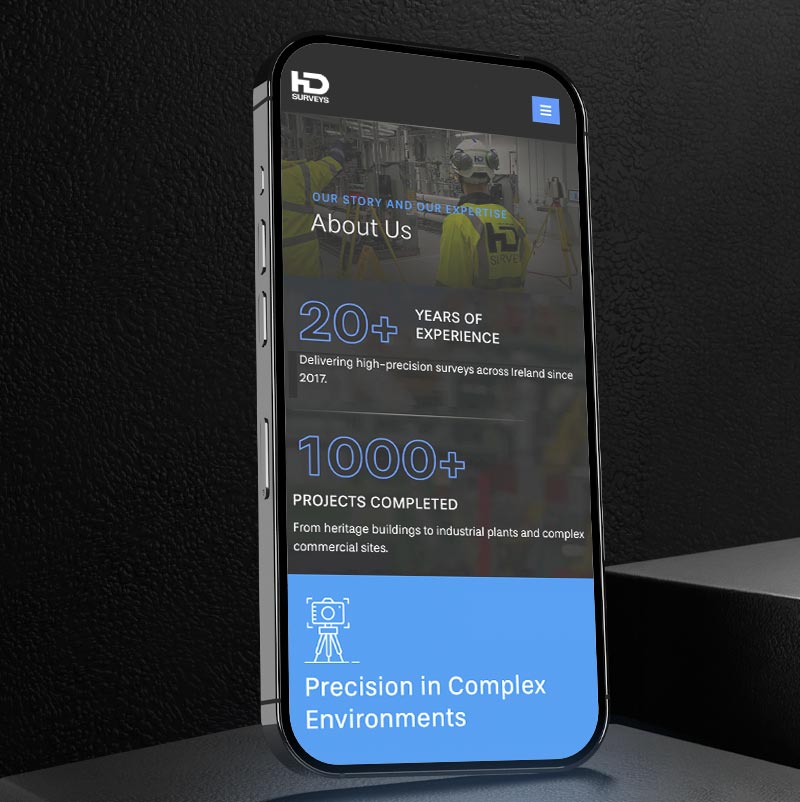 A smartphone displays a company website page showcasing the About Us section, highlighting B2B Web Design expertise with over 20 years of experience and 1,000+ projects completed in high-precision environments.